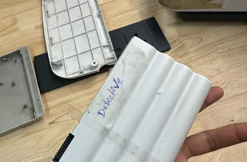 The ventilator's white battery pack with the word Defective handwritten on a strip of tape