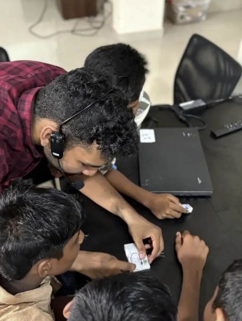 Basheer mentoring a student one-on-one on circuit connections