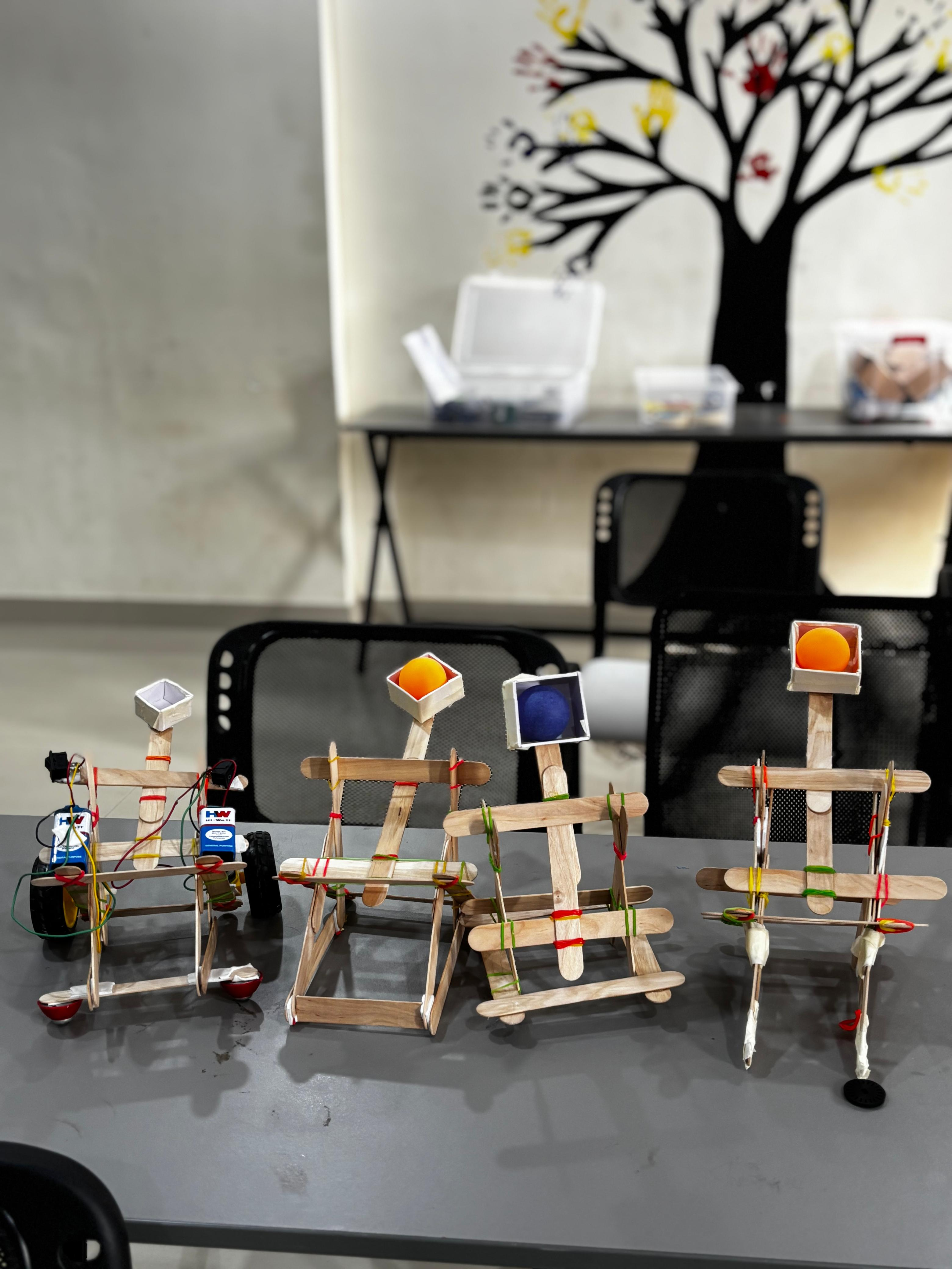 Students building a catapult from ice cream sticks and rubber bands